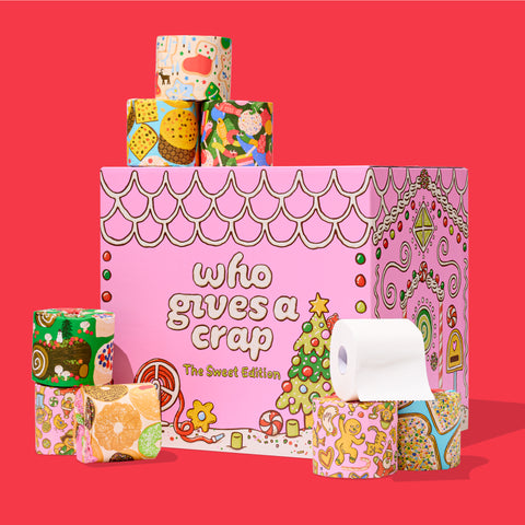 Colourful 'Who Gives a Crap' Sweet Limited Edition box decorated with candy illustrations, with toilet paper rolls stacked on top.